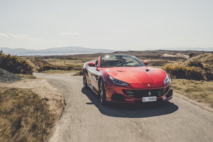 Red Ferrari Portofino M driving on a scenic road
