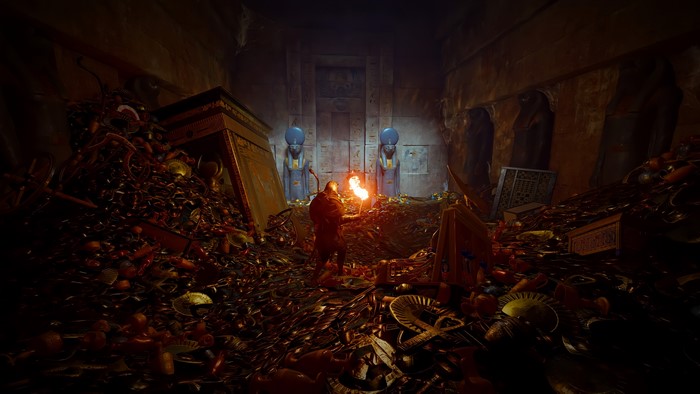 Bayek in a treasure-filled Egyptian tomb with torches