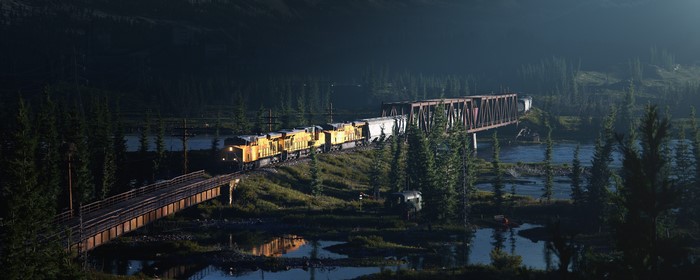Train crossing a bridge over a river at night