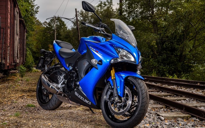 Blue Suzuki GSX-S motorcycle on train tracks