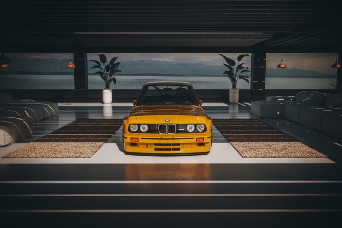 Yellow BMW M3 E30 in a modern garage