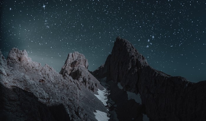 Rocky mountains under a starry night sky