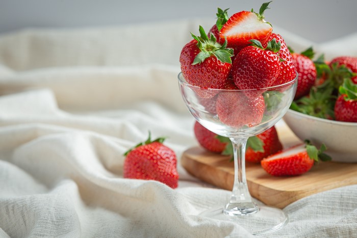 Strawberries in a wine glass on a cutting board