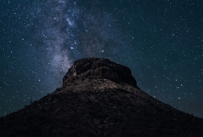 Mountain peak under the Milky Way and starry night sky