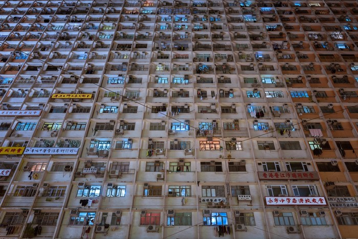 Apartment building at night with many windows and signs