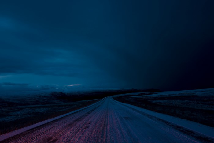 Snowy road in a dark winter landscape