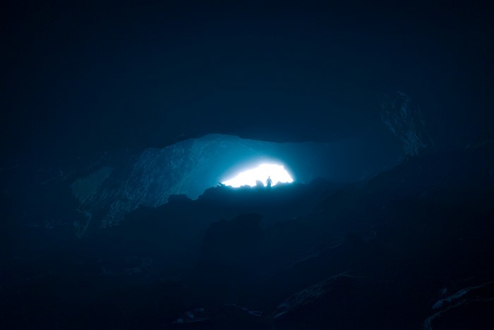 Silhouette of a person in a dark cave entrance