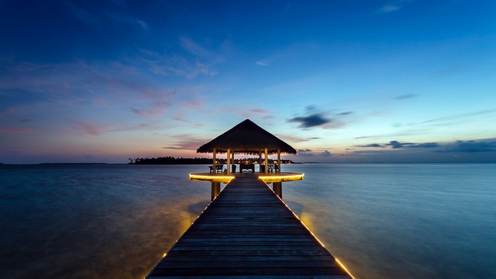Pier with gazebo over water at dusk