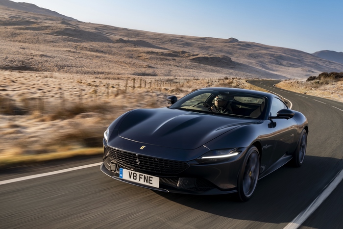 Black Ferrari Roma driving on a winding road