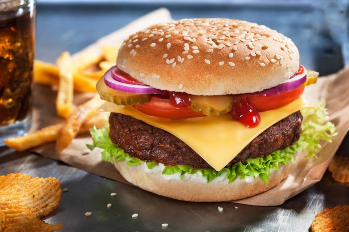 Cheeseburger with lettuce, tomato, onion, pickles, and fries