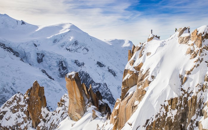 Hikers on a snowy mountain peak in the Alps