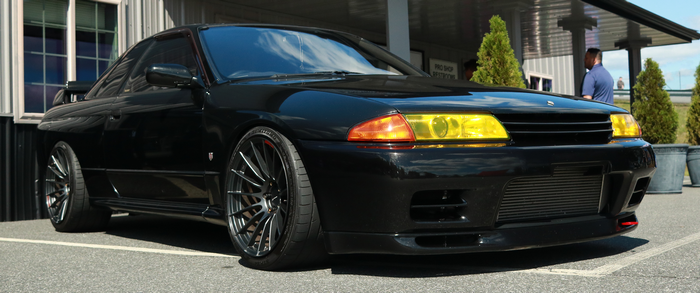 Black Nissan GT-R R32 with yellow headlights