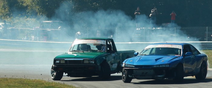 Drifting cars on a race track with smoke