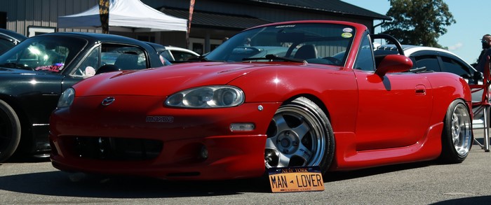 Red Mazda Miata convertible with custom wheels