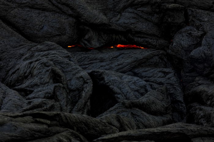 Molten lava glowing through dark volcanic rock formations
