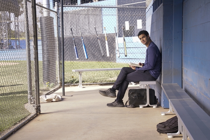 Walter O'Brien reading a book in a dugout