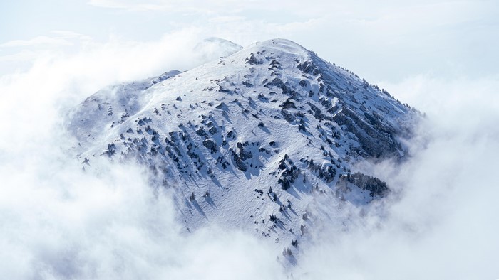 Snowy mountain peak emerging from clouds in France