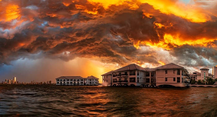 Stormy sunset over flooded buildings and city skyline