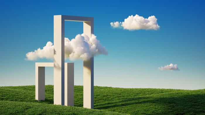 Abstract geometric structures in a grassy landscape under a blue sky
