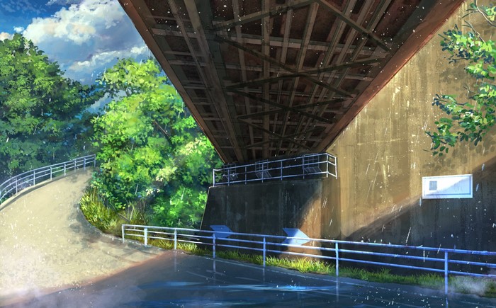 Path under a bridge with trees and clouds