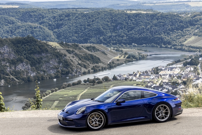 Blue Porsche 911 GT3 Touring with scenic river view