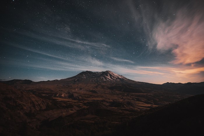Mountain under a starry sky with clouds