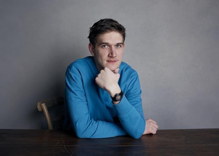 Bo Burnham sitting at a table