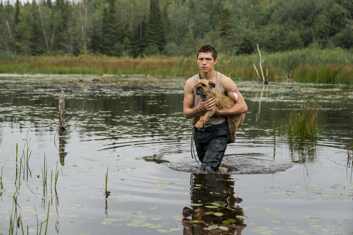 Tom Holland carries dog through water in Chaos Walking