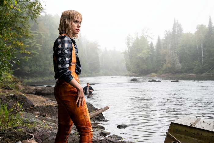Daisy Ridley in orange overalls by the river