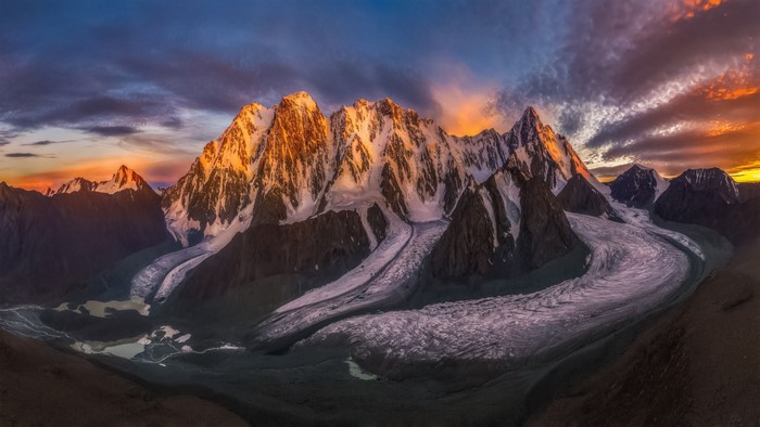 Sunlit Snowy Mountains with Serene Sky by Mr. Wang