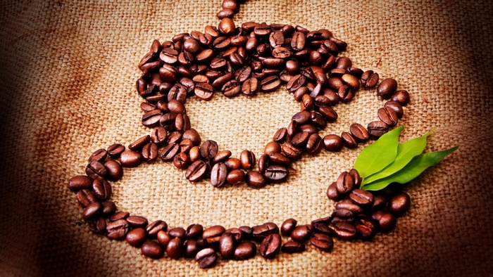 Coffee beans arranged in a cup shape with leaves