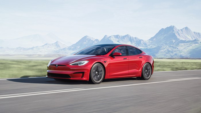 Red 2021 Tesla Model S Plaid driving on a road