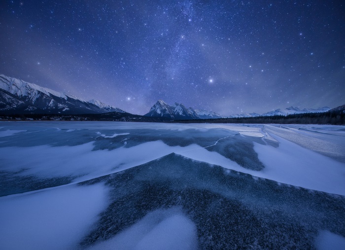 Starry Night Over Frozen Lake and Mountains