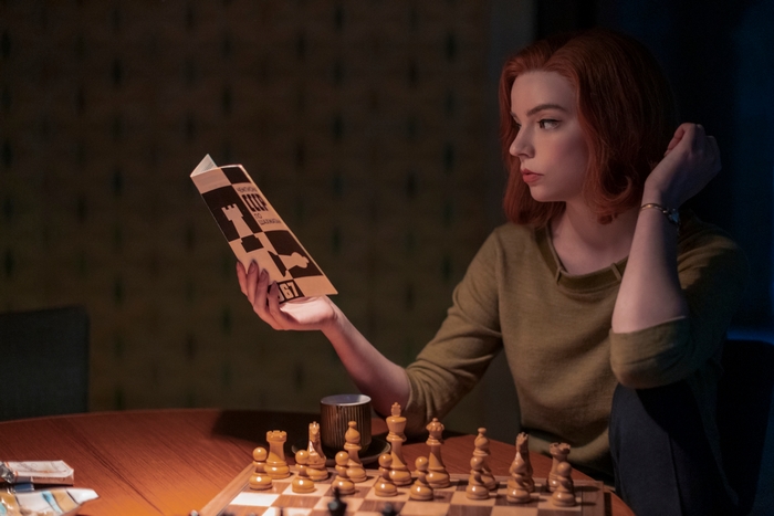 Anya Taylor-Joy as Beth Harmon reading a chess book