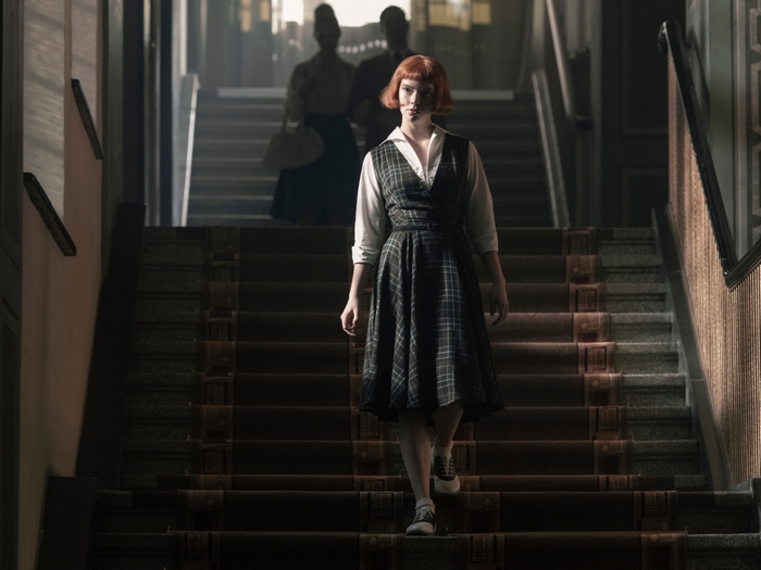 Beth Harmon walking down stairs