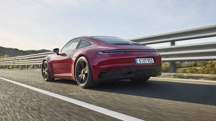 Red Porsche 911 Carrera GTS driving on road