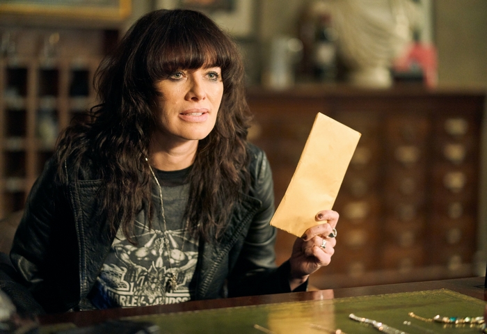 Lena Headey holding an envelope