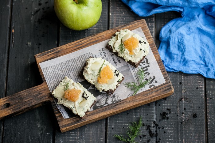 newspapers, cutting board, bread, apples, food, eggs, fruit