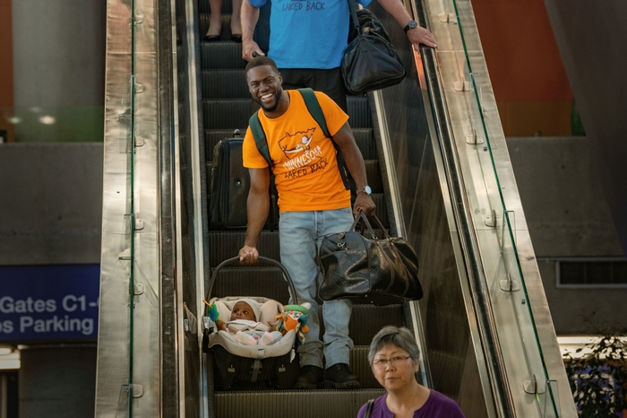 Kevin Hart with baby on escalator