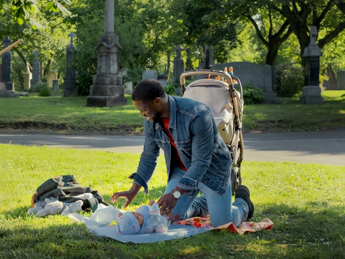 Father changing baby's diaper in cemetery