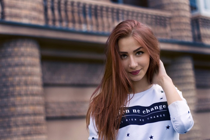 Young woman with red hair wearing a white sweatshirt