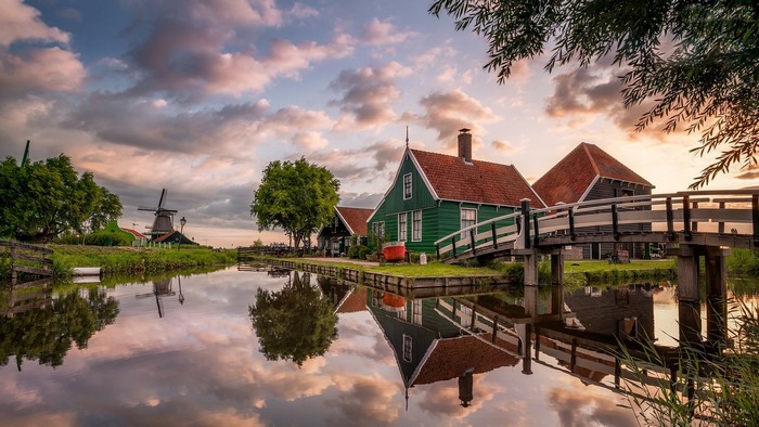 Dutch windmill and houses reflecting in water