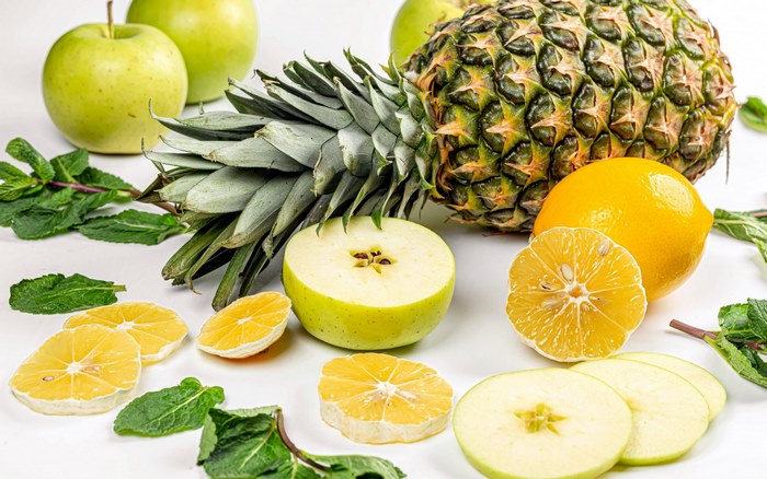 Fresh pineapple, apples, lemons, and mint leaves