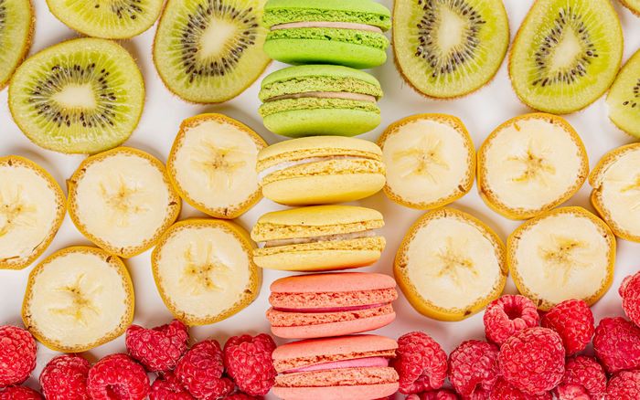 Still life of macarons, kiwi, banana, and raspberries