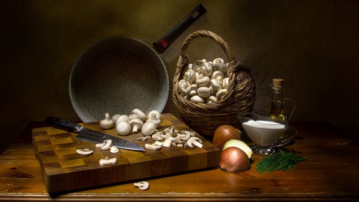 Still life of mushrooms, onions, and cream with a frying pan