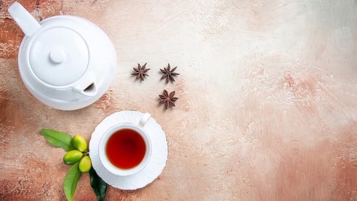 Tea in a cup with star anise and kumquats