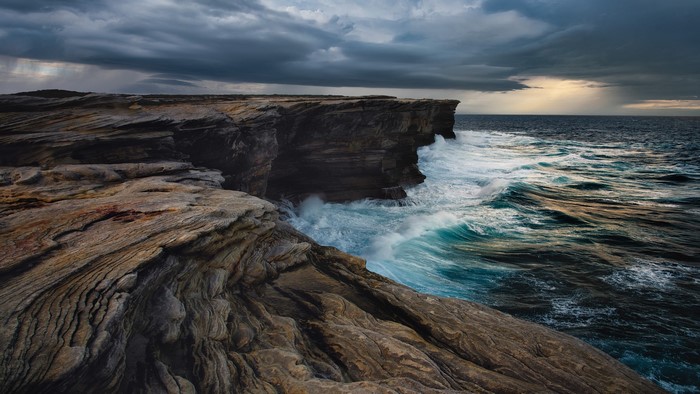 Dramatic Cliff and Sea Landscape with Cloudy Sky
