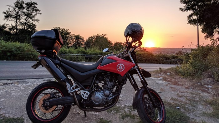 Yamaha XT660X motorcycle with helmet at sunset