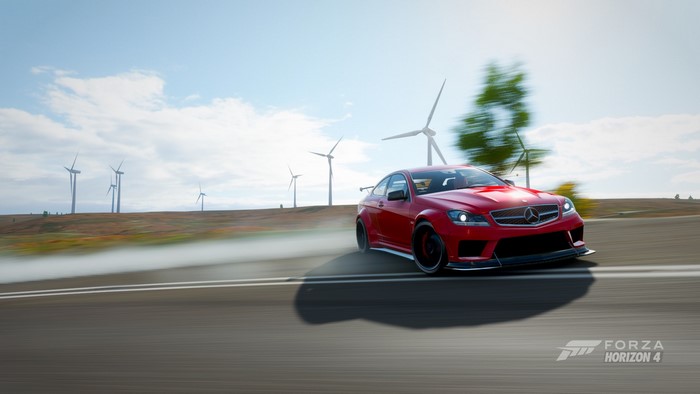 Red Mercedes C63 AMG drifting near wind farm in Forza Horizon 4
