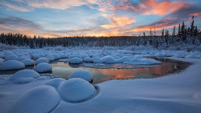 Snowy landscape with ice formations at sunset